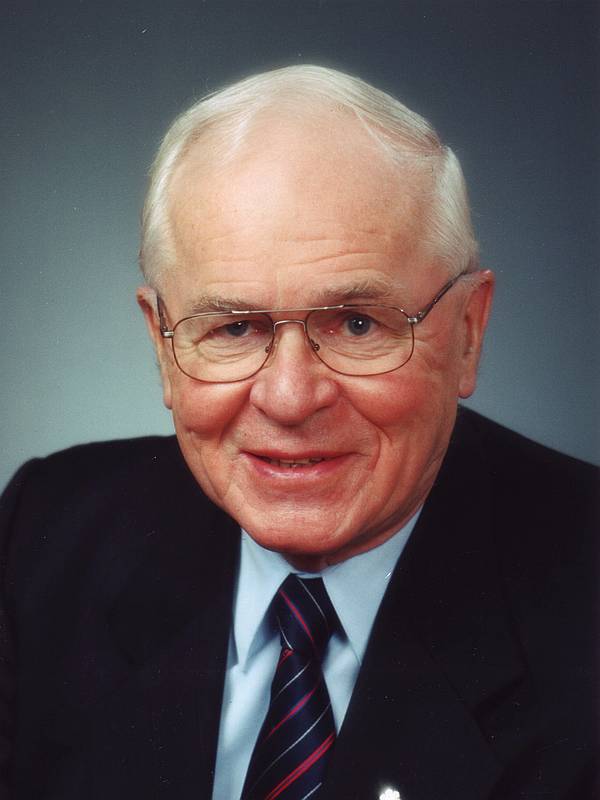 Doug Roche sitting facing the camera, smiling
